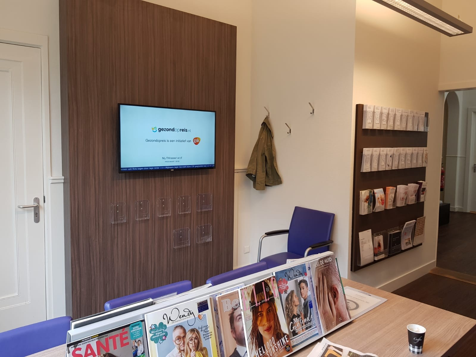 Wachtruimte van DC klinieken met het narrowcasting-scherm aan de muur.