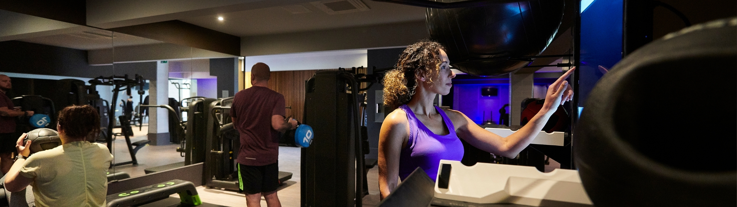 Vrouw die in een sportschool een scherm aanraakt.