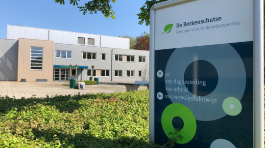 Foto van het gebouw van VSO De Berkenschutse, samen met een bewegwijzering.