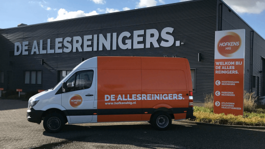 Bedrijfsbus van Hofkens voor het kantoor van Hofkens. 