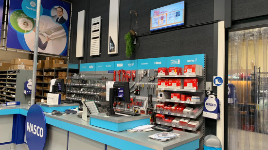 Zijaanzicht van de kassa binnen een Wasco-winkel.